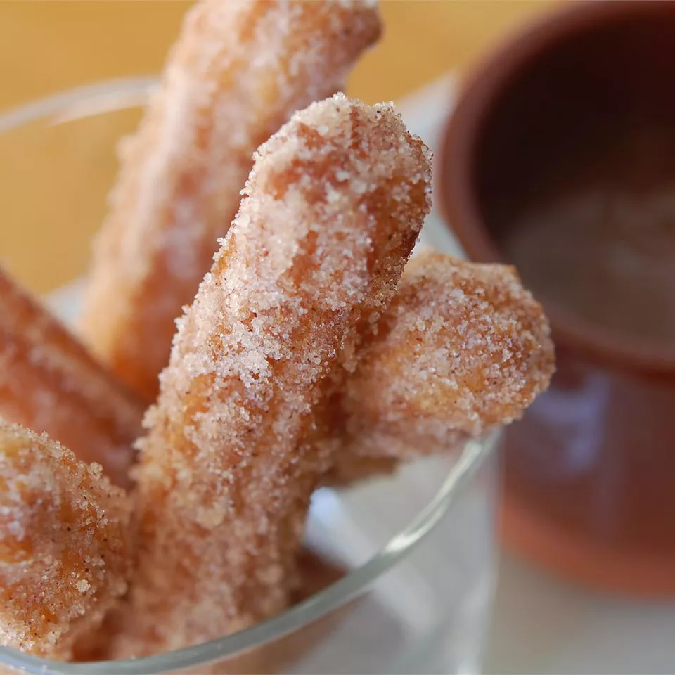 closeup of sugared churros in a glass bowl