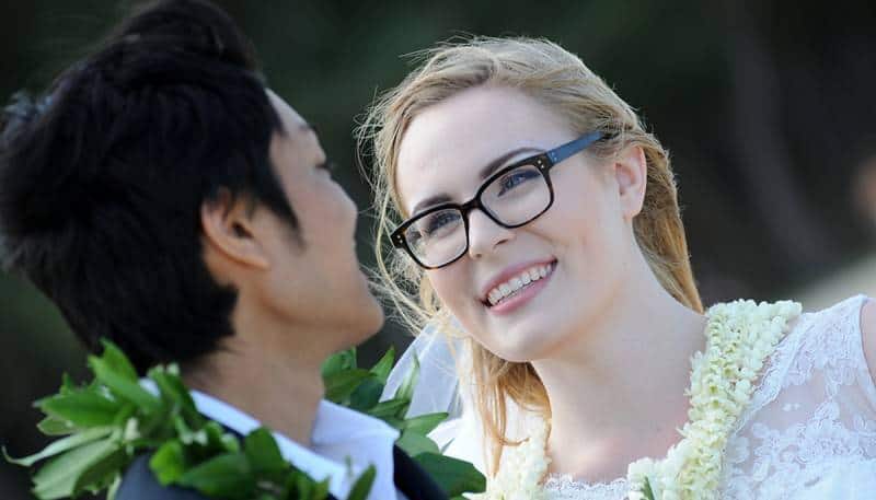 bride wearing her glasses lookin int the eyes of her love