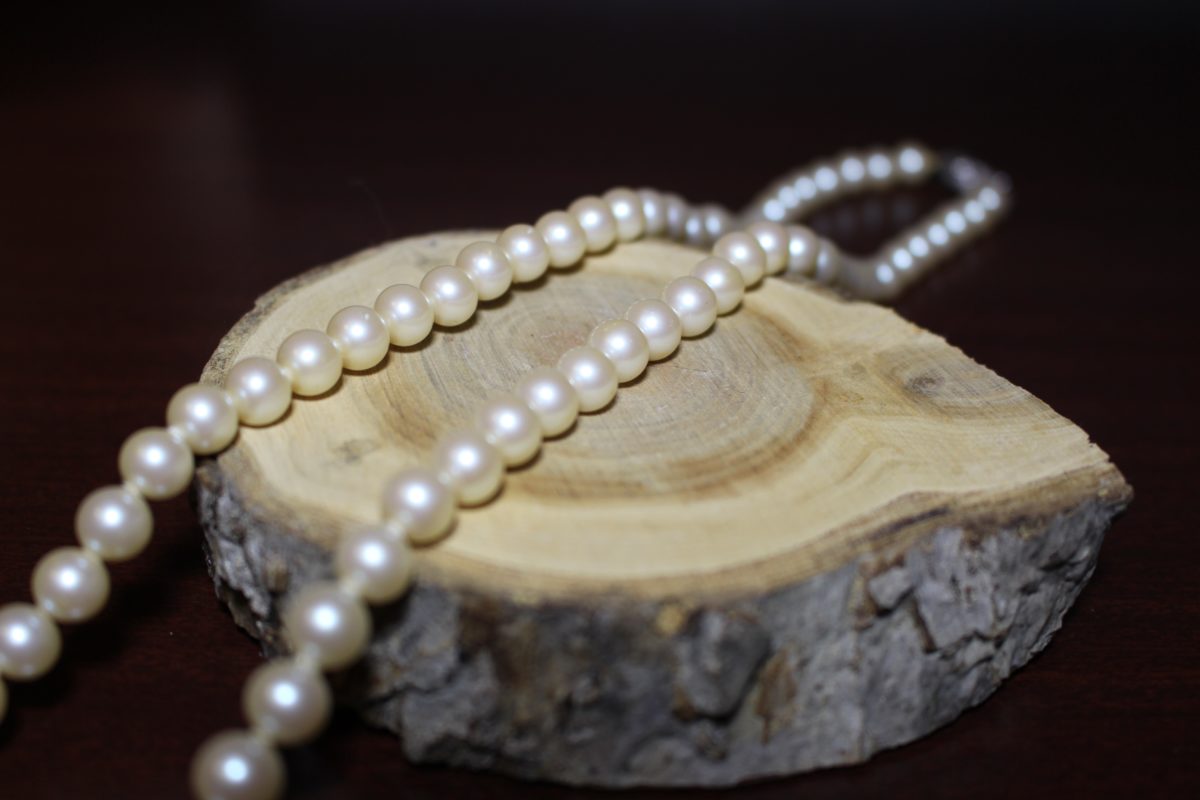 gold necklace on brown wooden table