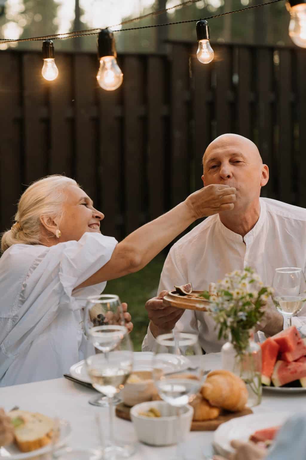 Man in White Dress Shirt Sitting Beside Woman in White Dress