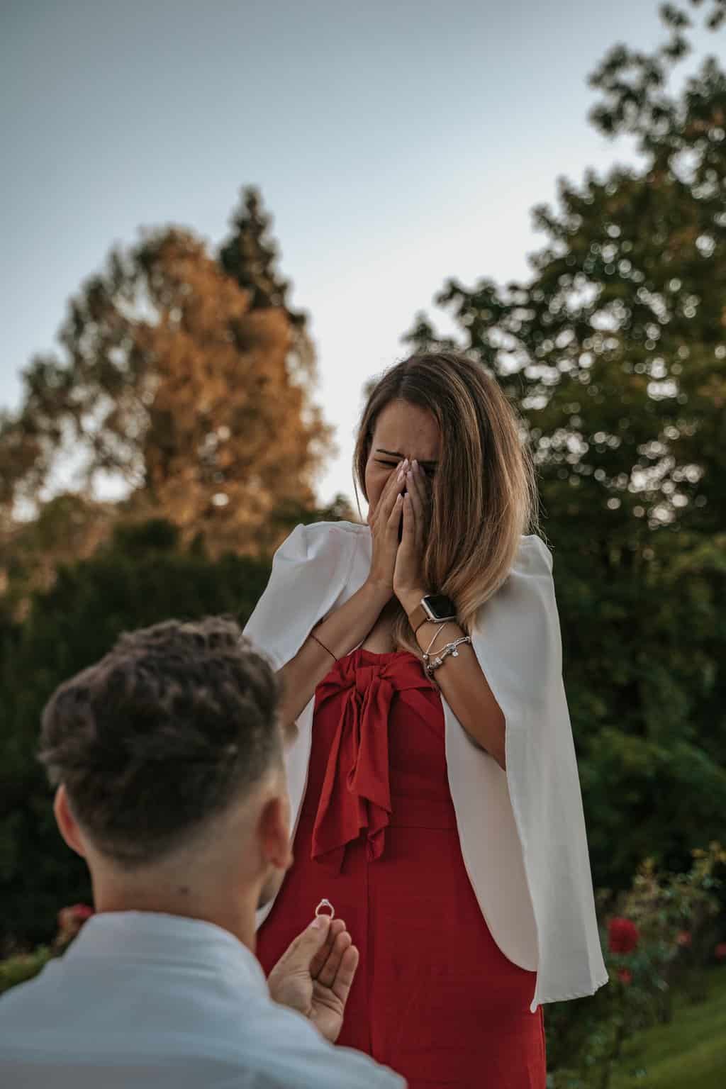 man in white suit kissing woman in red dress