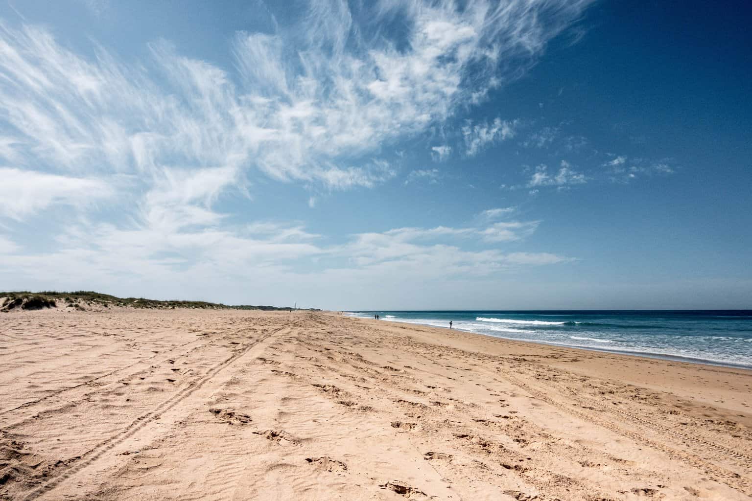 brown sand near blue sea under blue sky during daytime