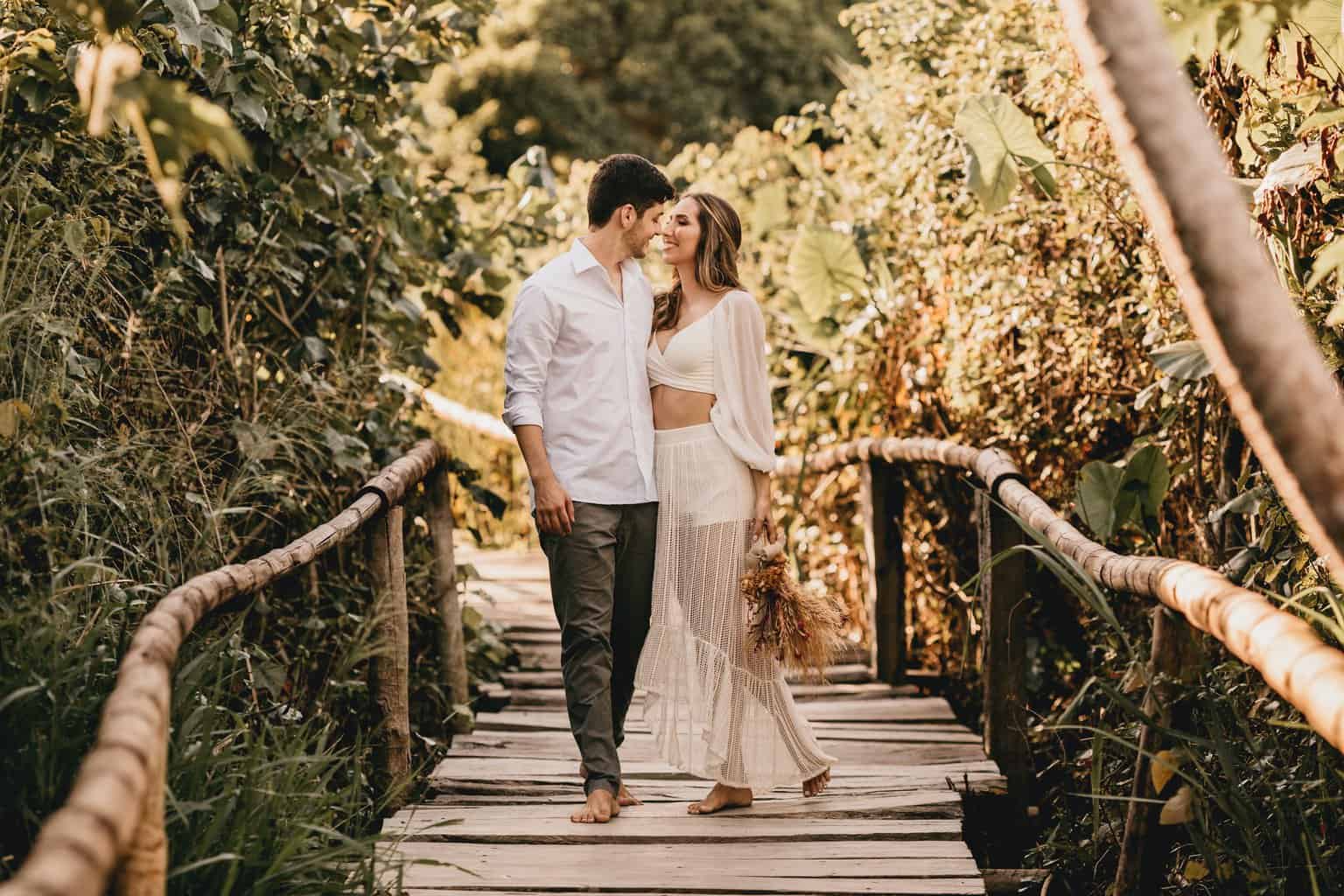 man and woman walking on wooden bridge during daytime