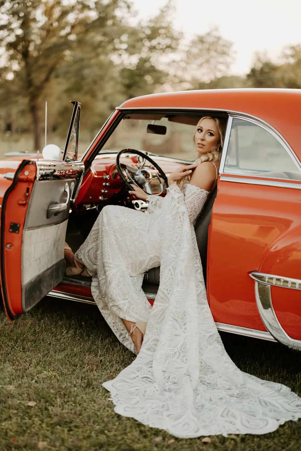 Free A Woman in Her Wedding Dress Sitting in a Vintage Car Stock Photo