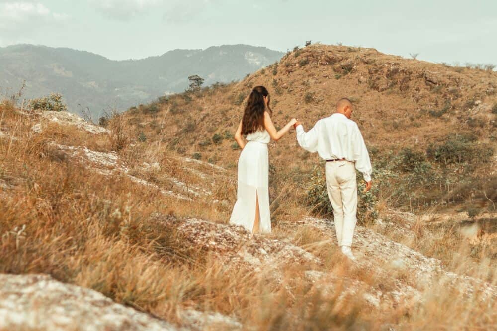 couple standing on brown grass field during daytime