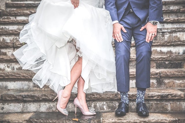Bride stands next to the groom in a white wedding dress
