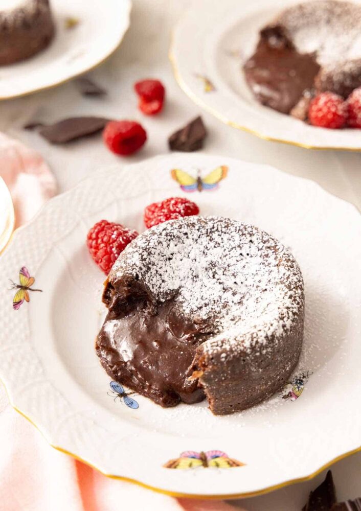 A plate with a chocolate lava cake with the molten center pouring out.