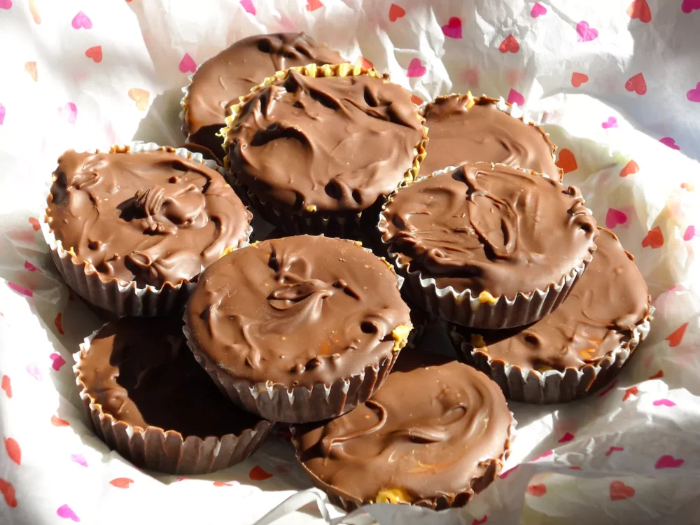 close up view of Chocolate Peanut Butter Cups on white paper with a heart design