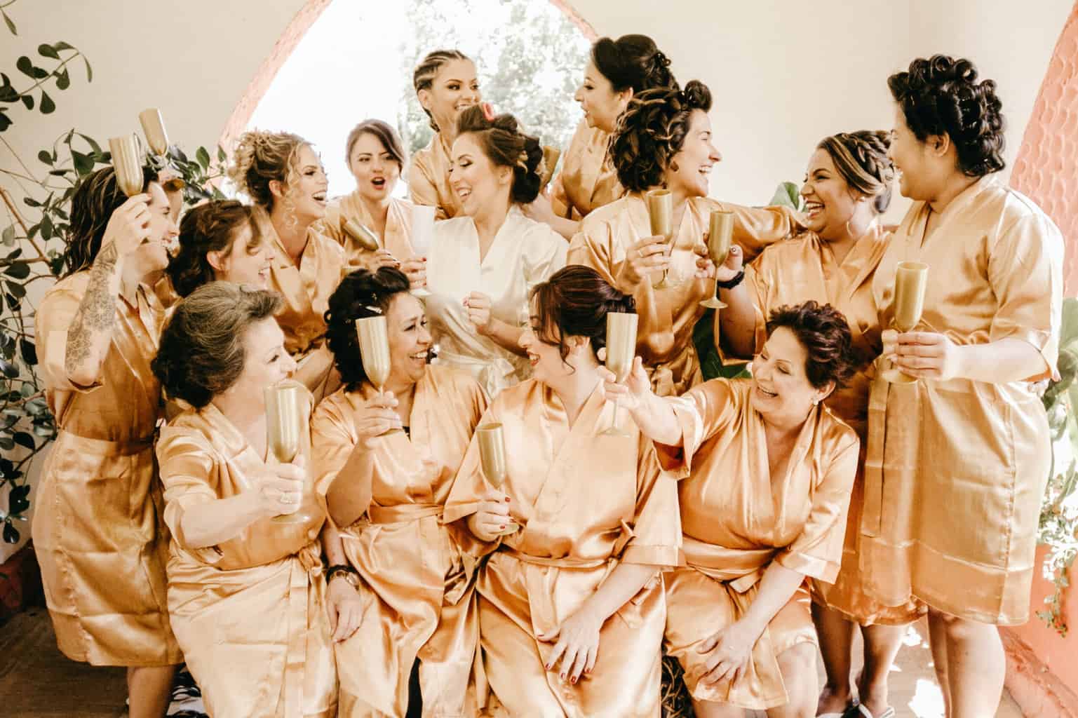 Bride with her bridesmaids wearing gold dressing gowns