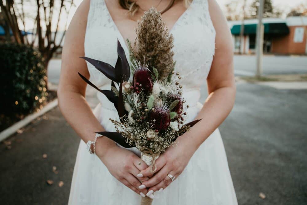 a woman in a white dress holding a bouquet of flowers