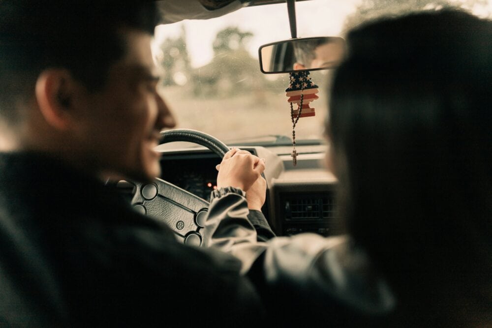 31 Fun Car Trip Games for Couples (Keep the Laughs Going All the Way!) 5 A man driving a car next to a woman