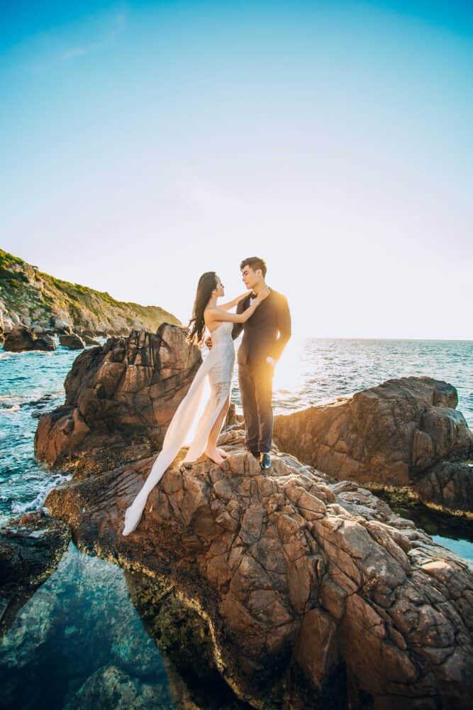 Free Man and Woman Standing on Brown Rock Under Blue Sky Stock Photo