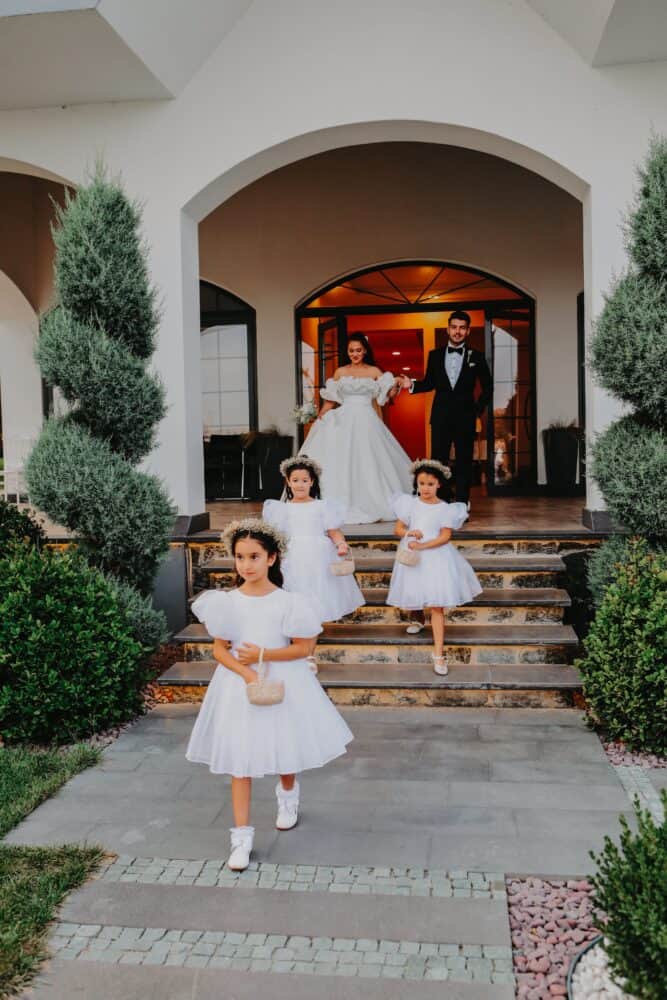 Free A Cute Flower Girls Walking Together with the Bride and Groom Stock Photo