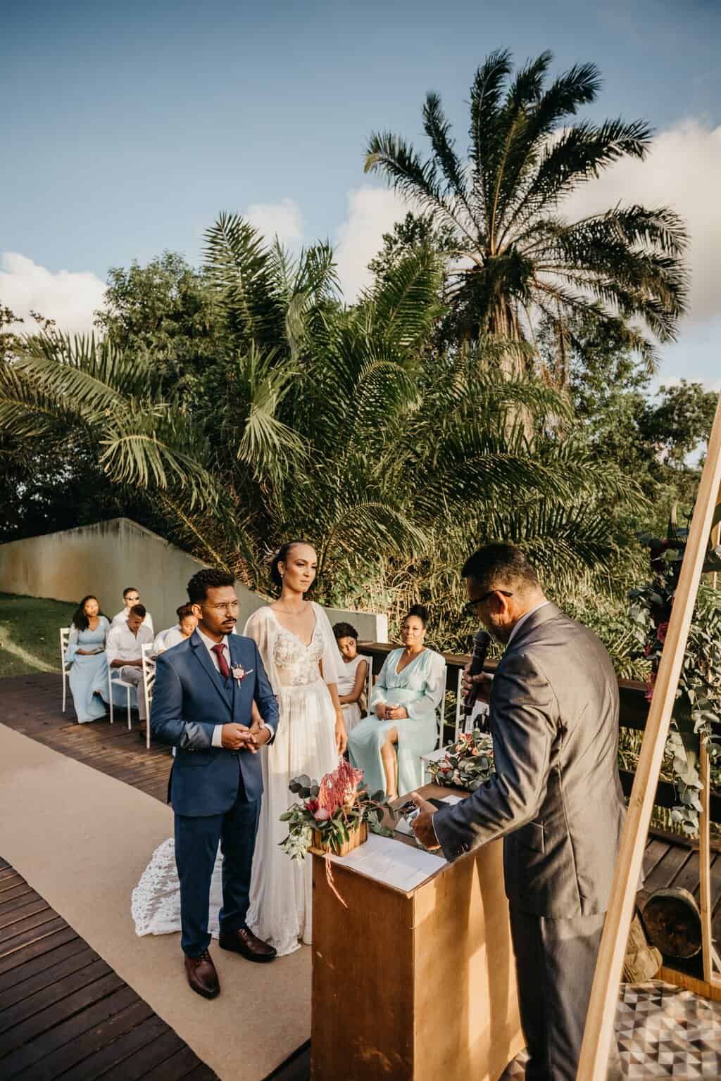 Free Multiethnic couple on wedding ceremony with unrecognizable officiant and guests Stock Photo