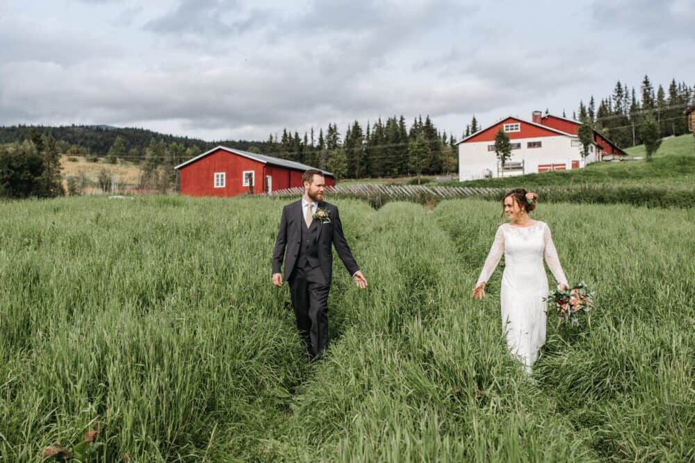 Free Man in Black Suit Walking on Green Grass Field Beside Woman in White Dress at Wedding Day Stock Photo