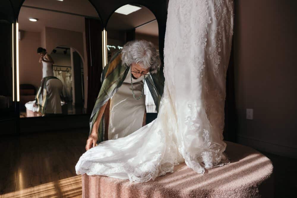 Free An Elderly Woman Fixing the Wedding Gown of the Bride Stock Photo